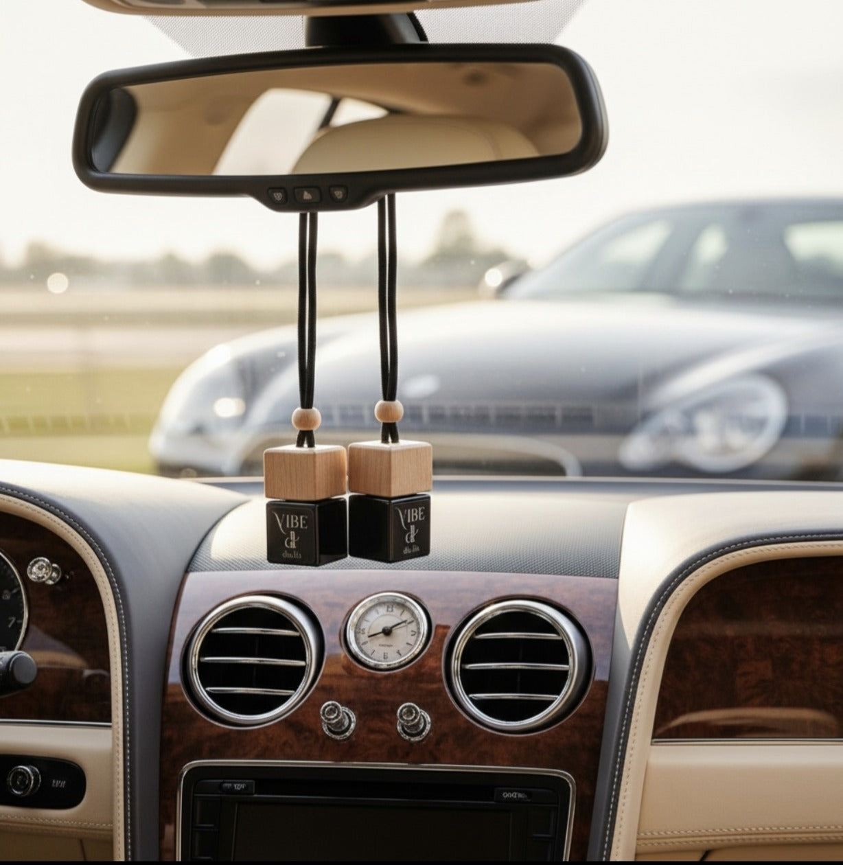 VIBE car freshener hanging in a luxury car interior — warm, addictive, upscale scent.