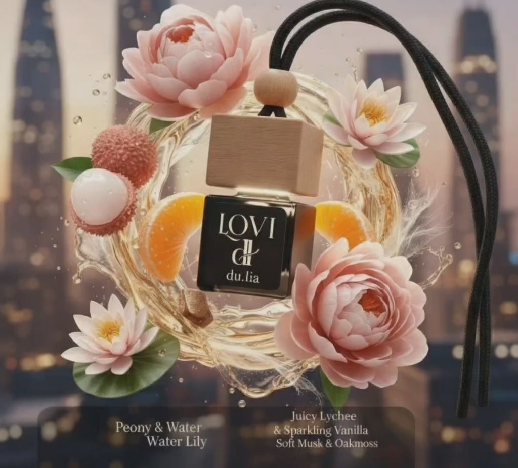 LOVI hanging car freshener surrounded by soft pink peonies and bright citrus elements.